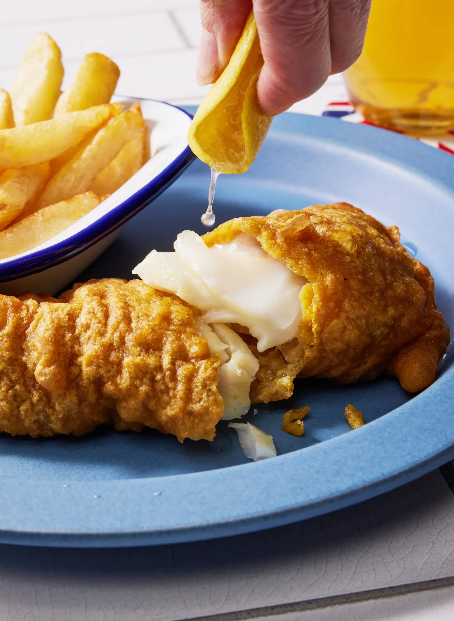 British style fish and chips with hand squeezing lemon