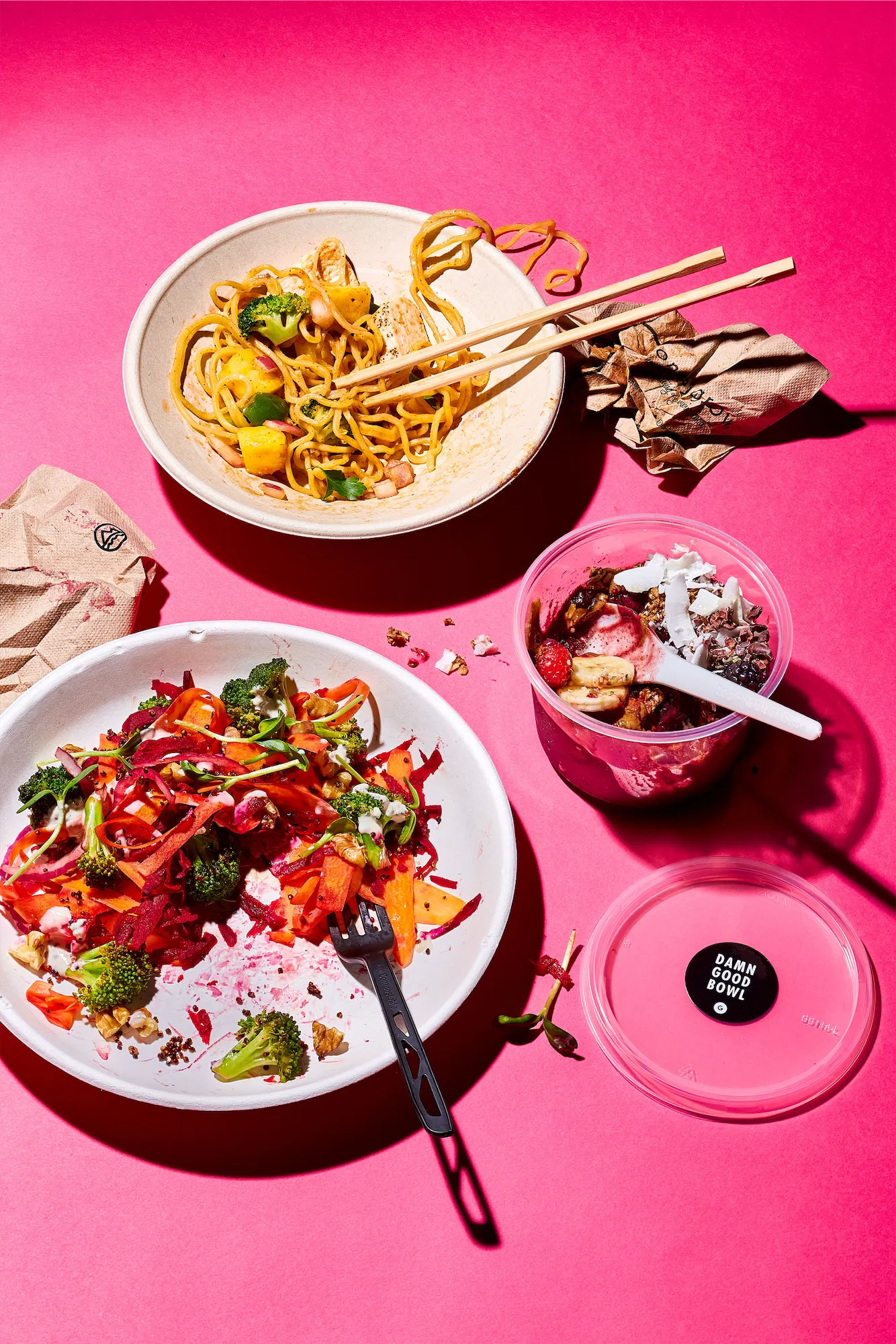 messy takeout food on pink background