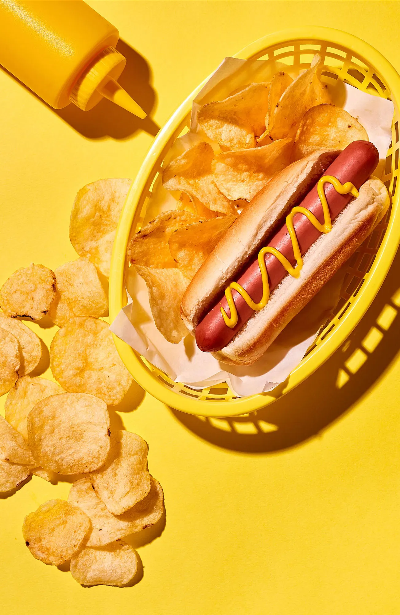 yellow scene with classic hotdog and potato chips in a plastic basket