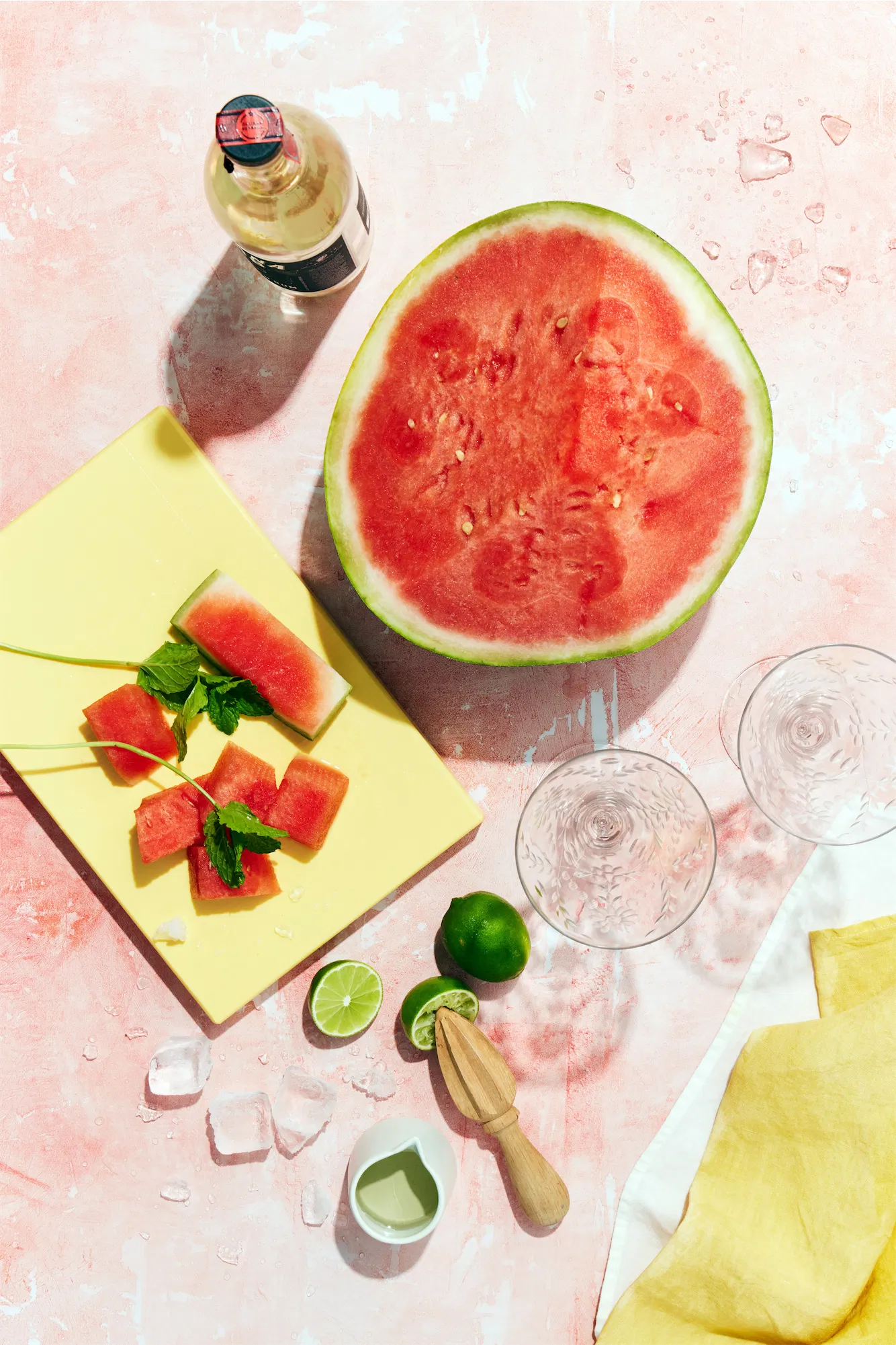 watermelon daiquiri recipe ingredients citrus reamer fresh lime on pink surface.
