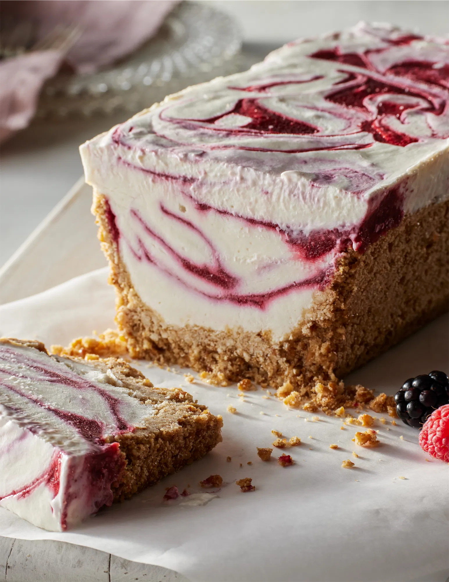 loaf shaped frozen berry yogurt pie cake with crumb crust on parchment paper