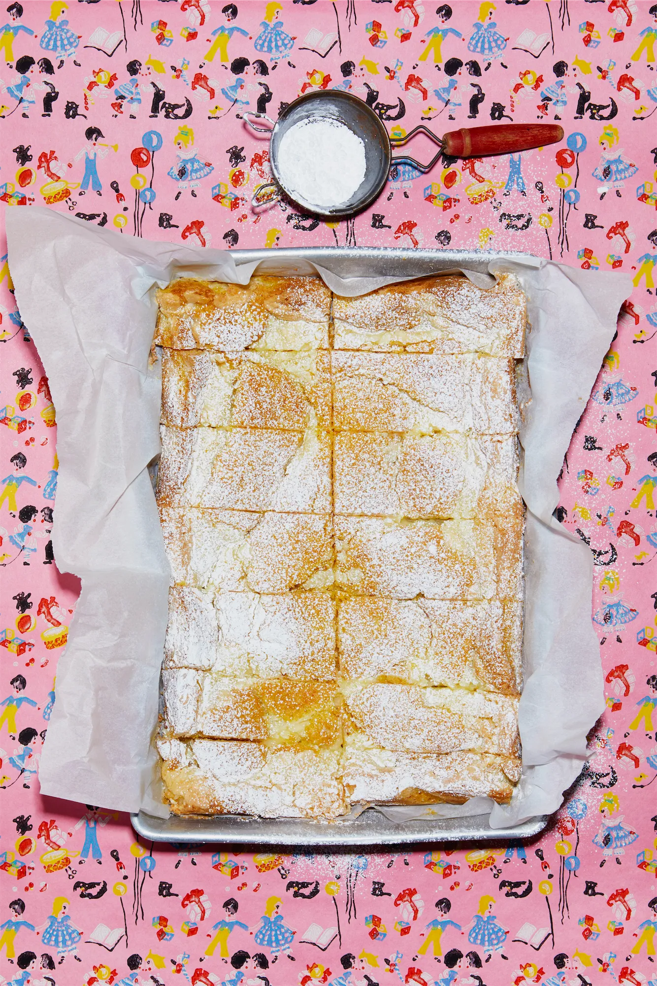 lemon sheet cake dusted with powdered icing sugar on a pink background illustrated with children