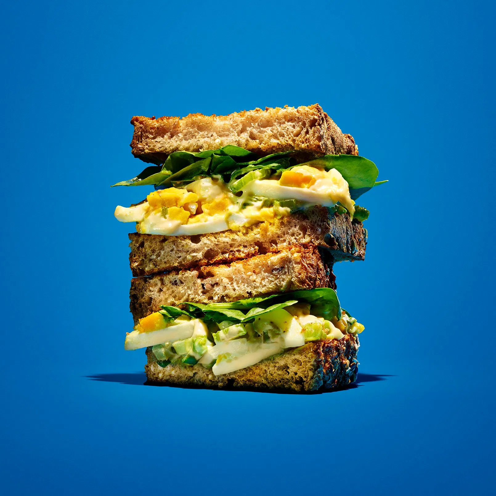 a heroic view of a stached egg sandwich on a blue background for kraft brand
