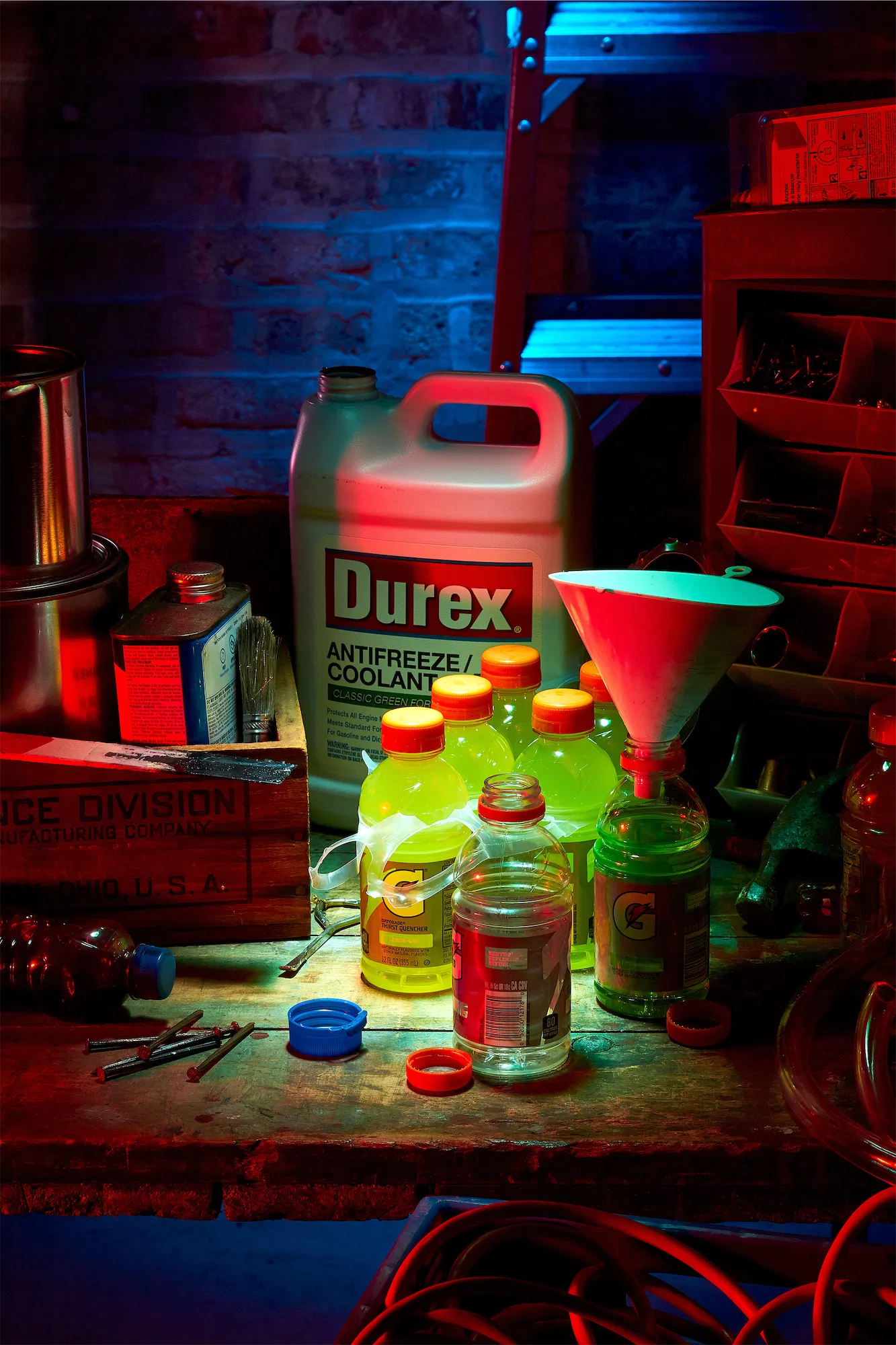 a night scene in a garage with bottles of green coolant and a red funnel