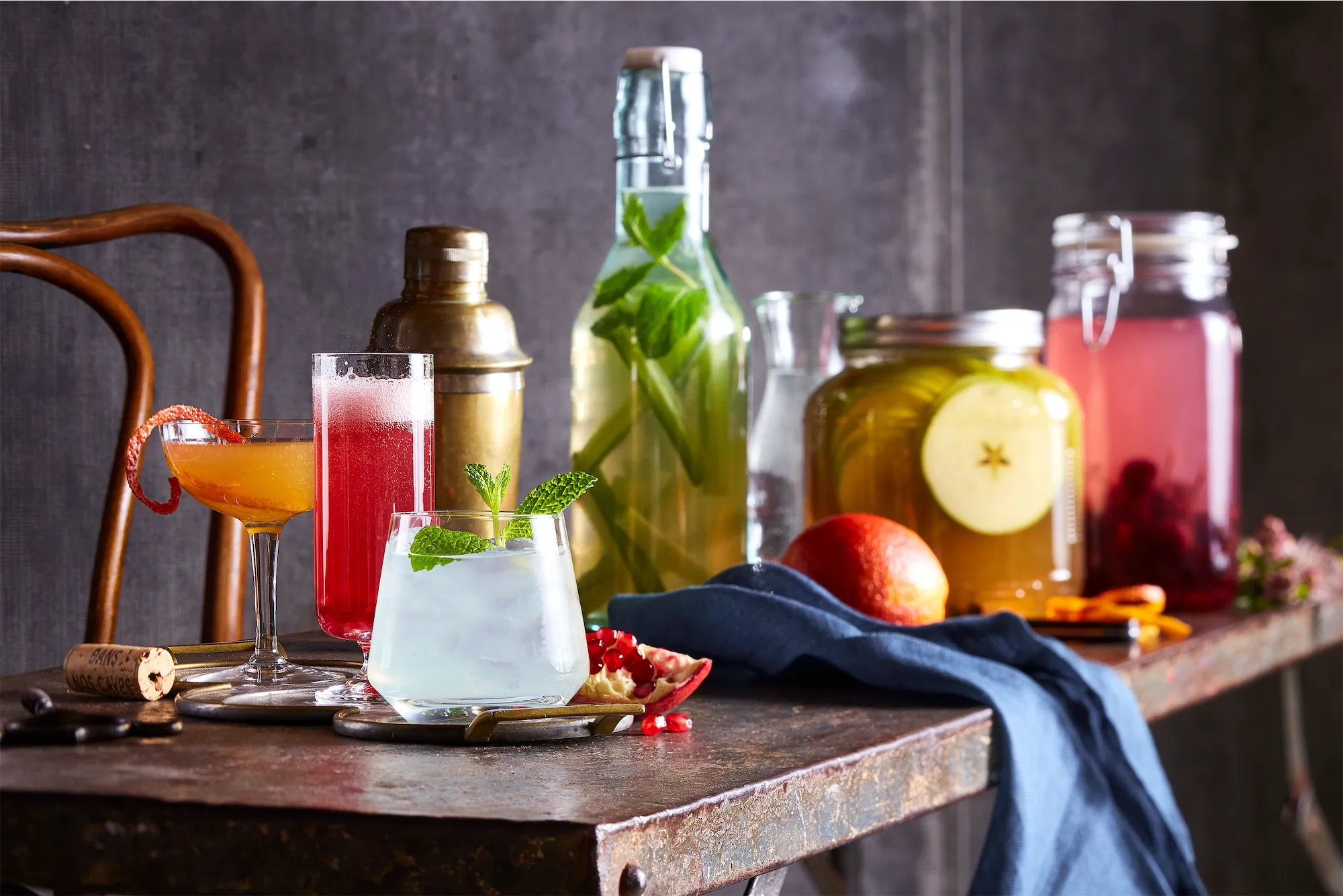 a long metal table filled with an assortment of beverages and cocktails