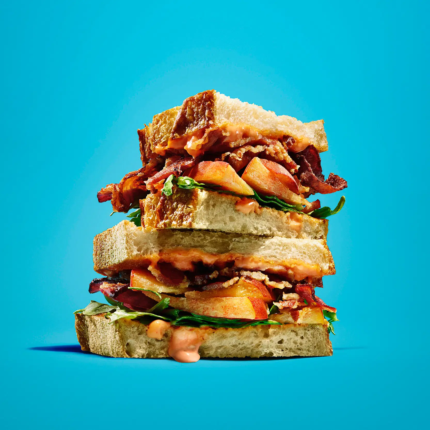 Kraft brand stacked sandwich filled with bacon and peach slices and dripping with cocktail sauce