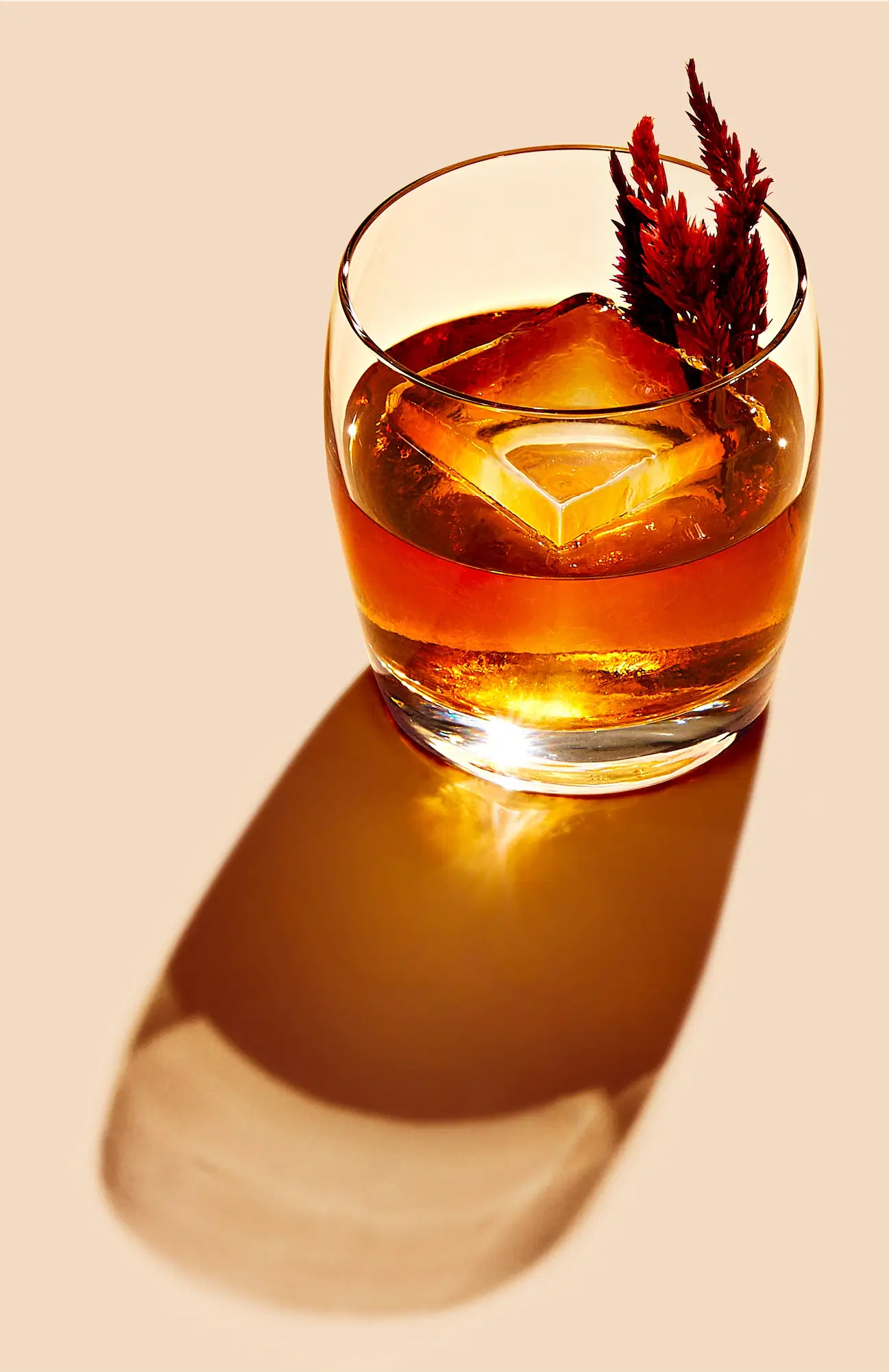 Amber Jim Beam bourbon cocktail old fashioned served in a rocks glass with a large ice cube