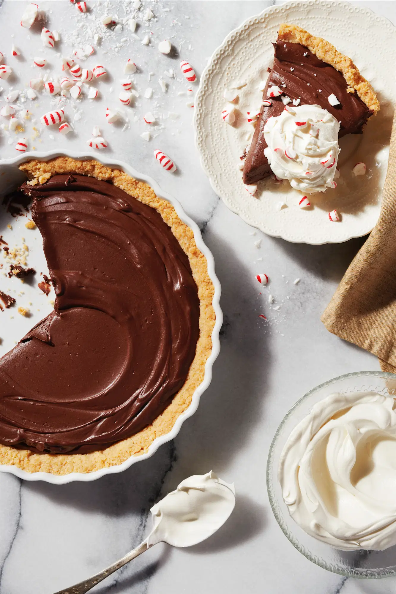 Crate and Barrel chocolate peppermint sea salt tart pie served with whipped cream and starlight mints on a marble surface