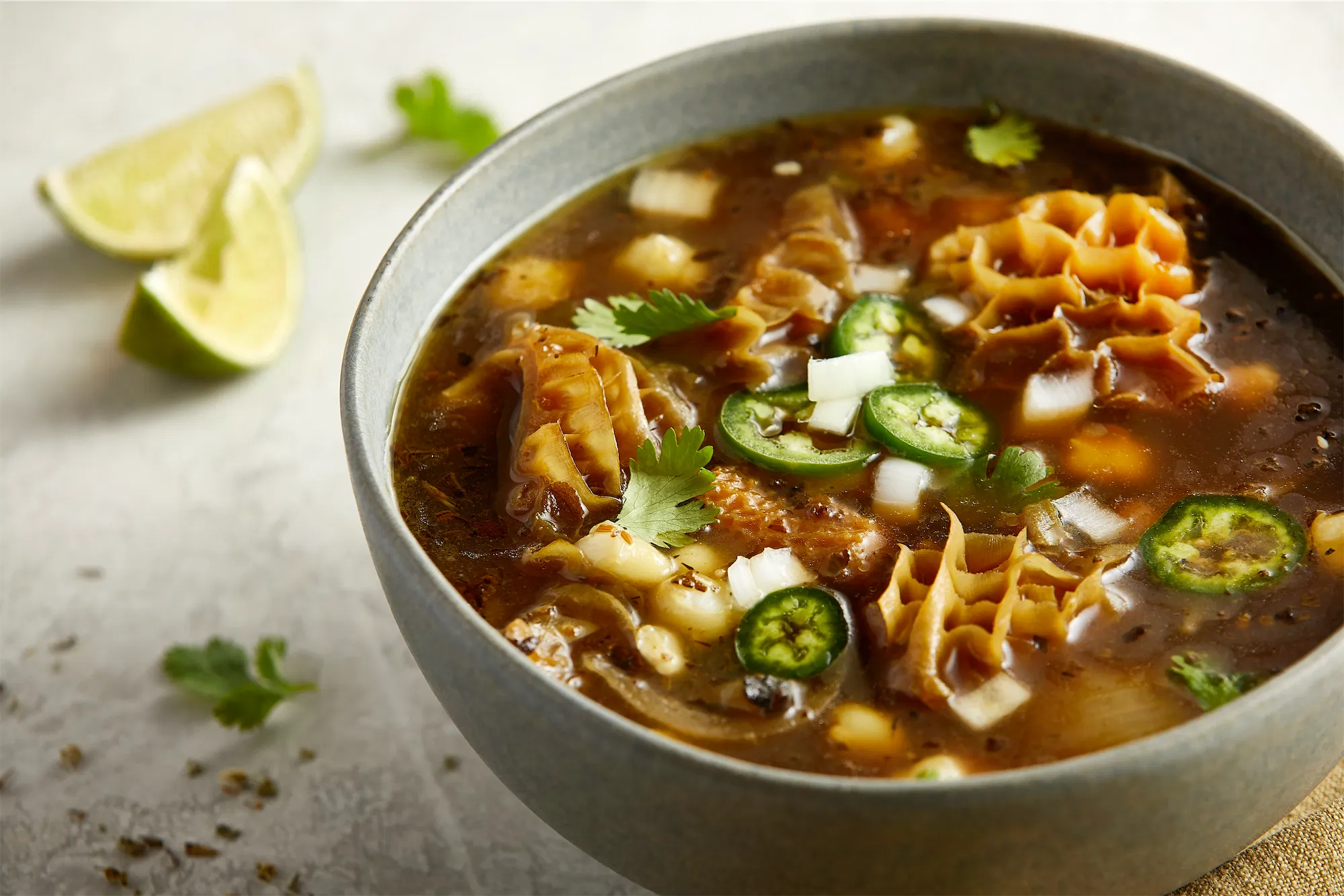 National beef brand honeycomb tripe soup with jalapeno cilantro and lime wedges