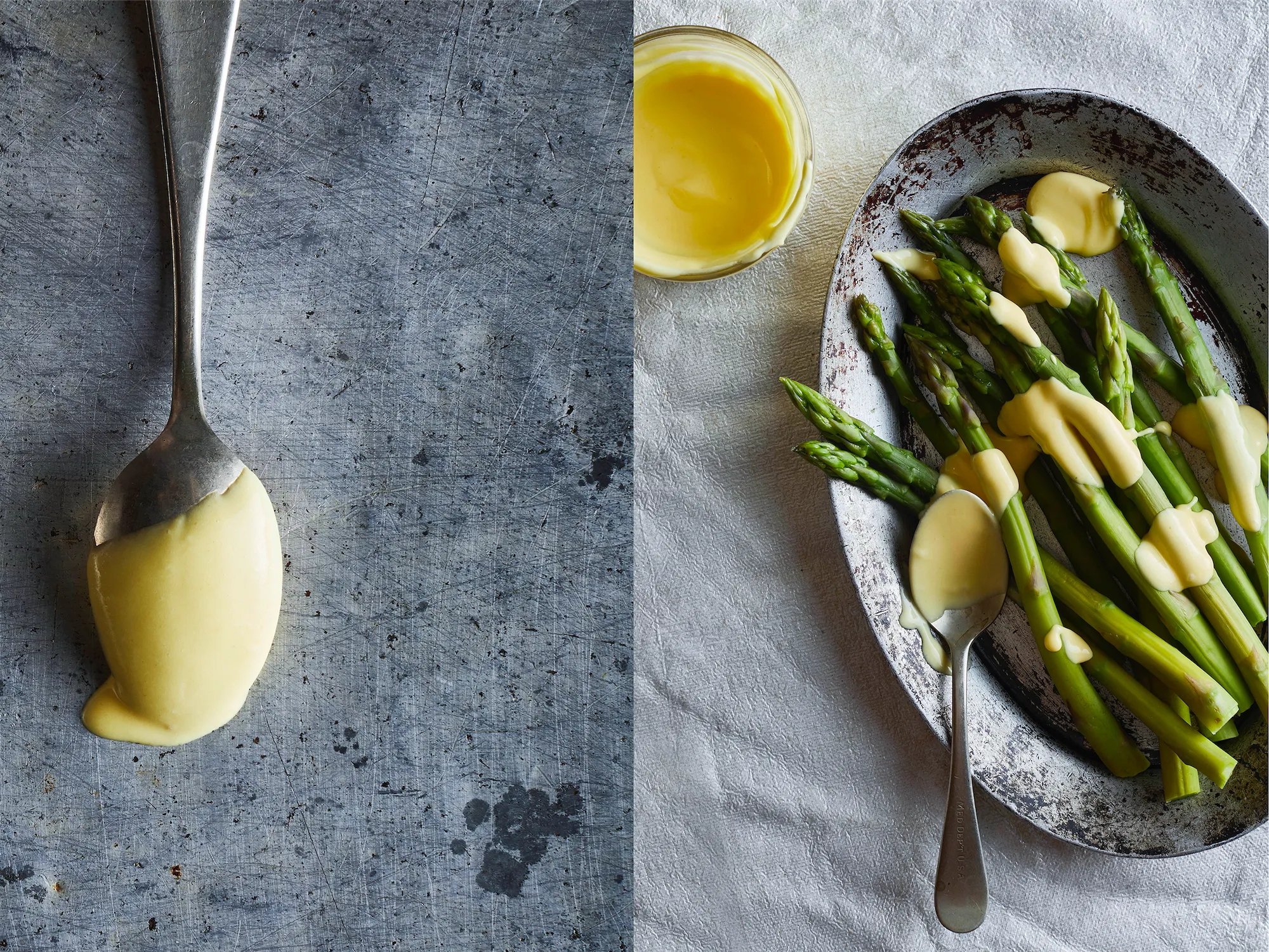 a pile of fresh steamed asparagus with hollandaise sauce on a metal plate on a grey surface with a spoon coated in the sauce