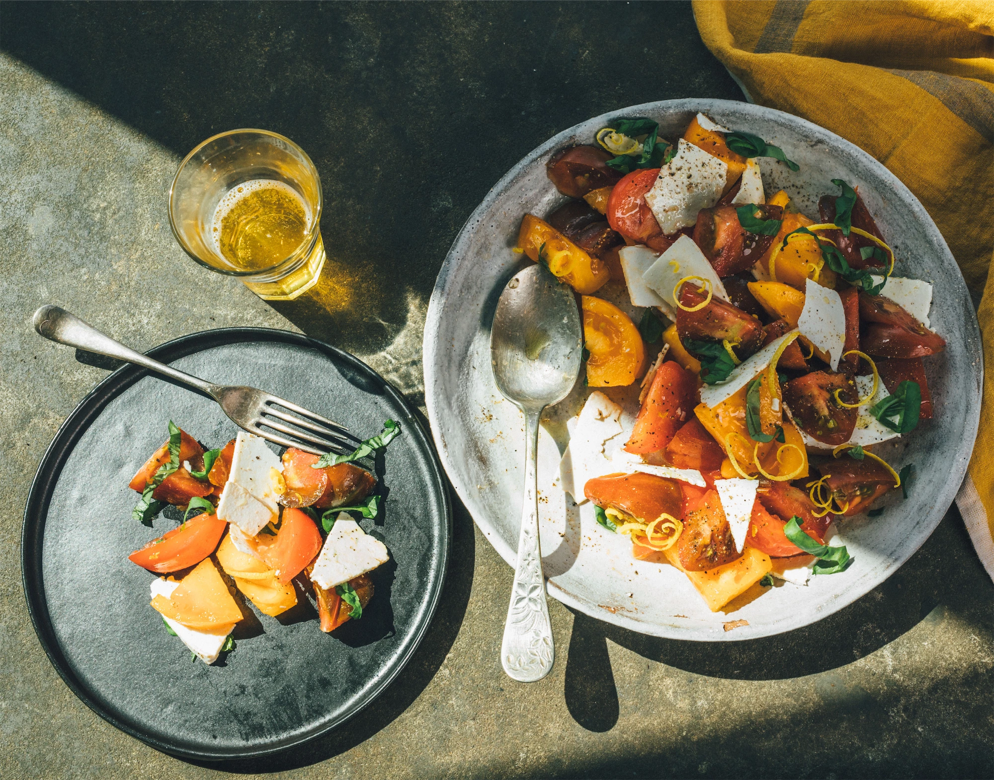 salad of ricotta salata and fresh tomatoes long hard shadows glass of beer