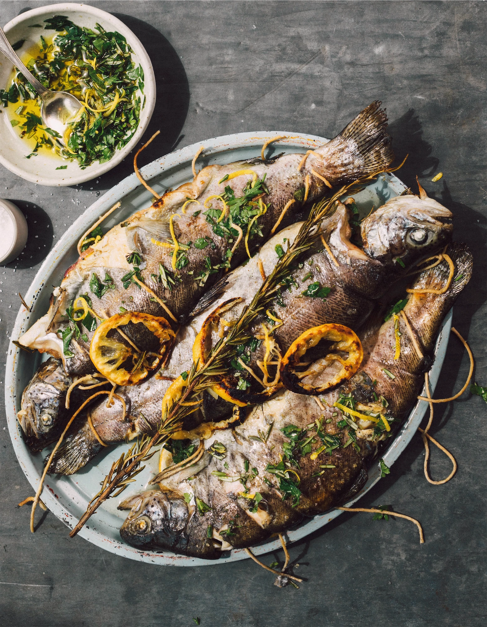 three grilled trout with lemon and herbs tied with string