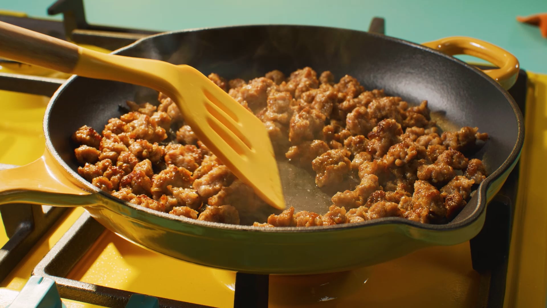 Johnsonville crave italian sausage lasagna in process in a yellow skillet with yellow spatula