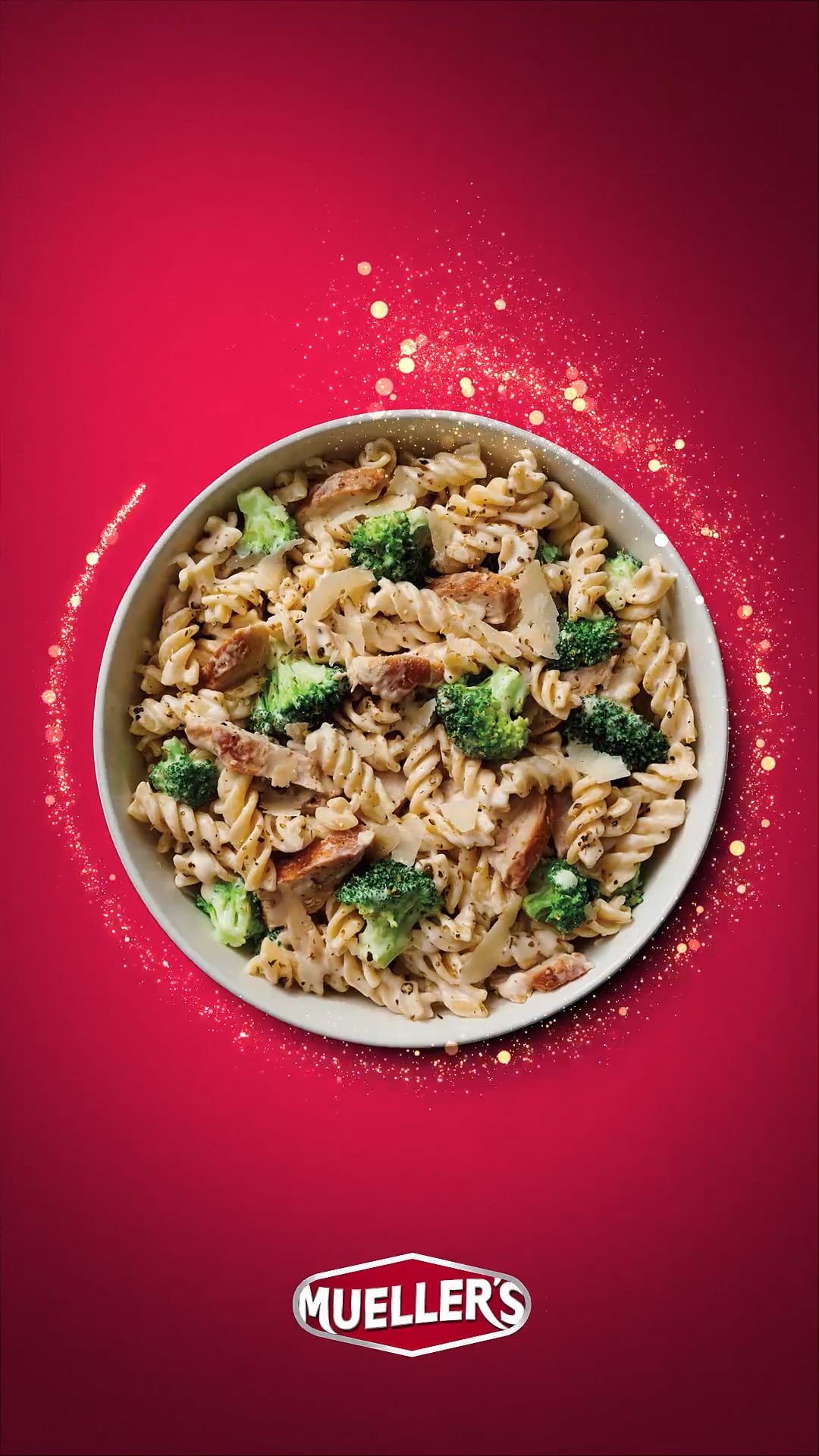 Muellers brand of pasta in a bowl with vegetables for thanksgiving smiles on red background