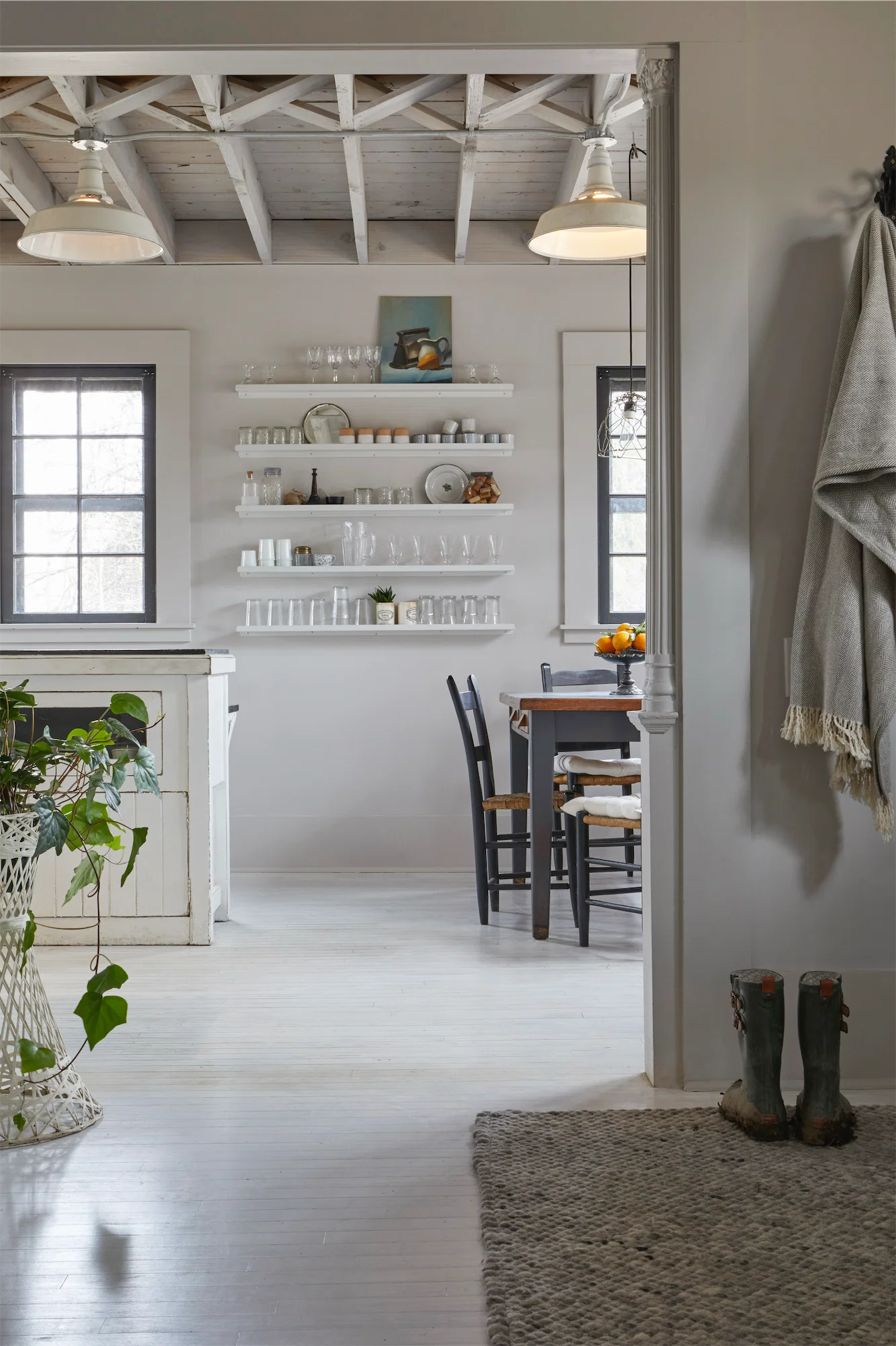 serene grey white view of kitchen from entryway open shelving roof beams white washed wooden floors