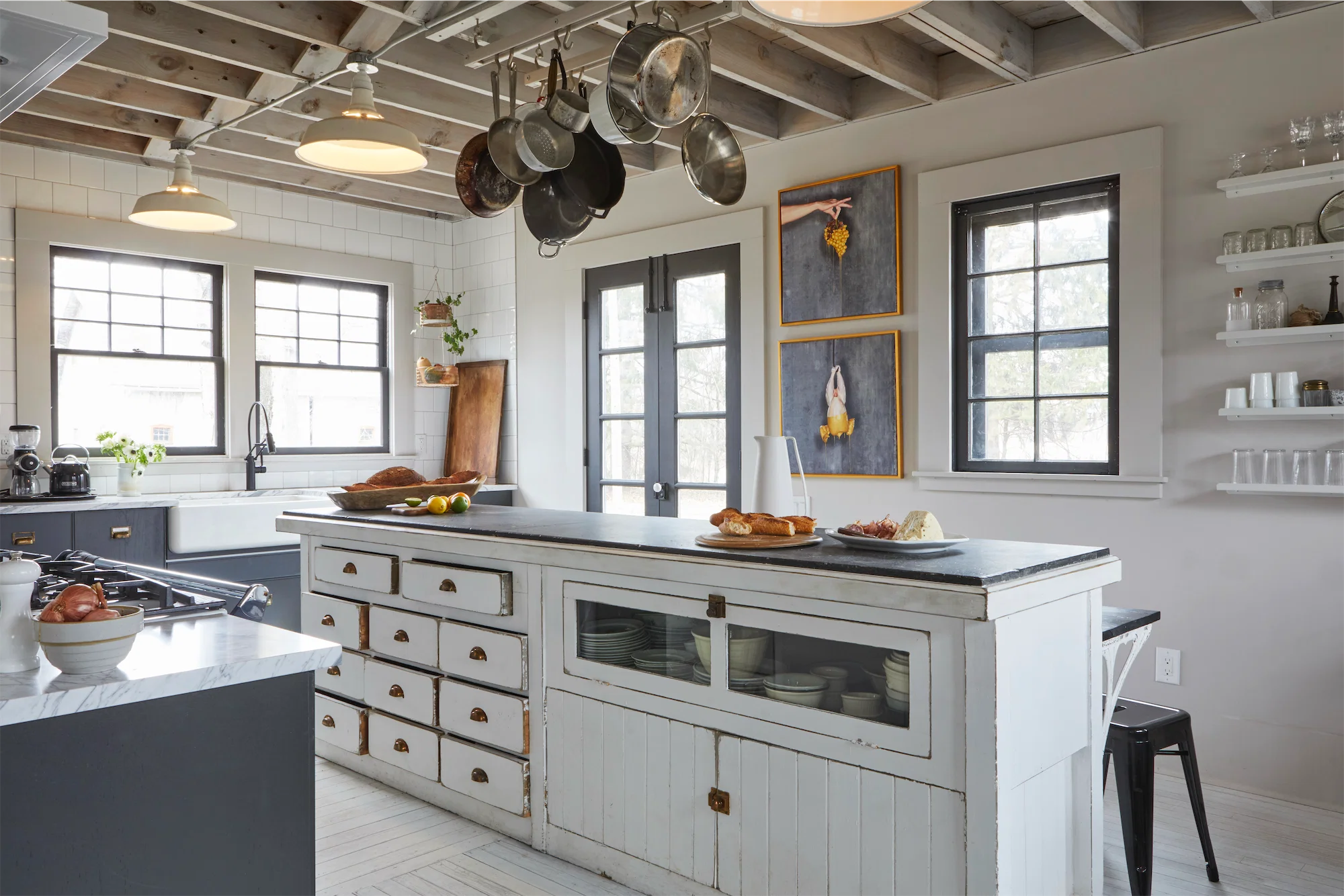 large black and white tasteful kitchen with vintage island soapstone marble finishes open shelving