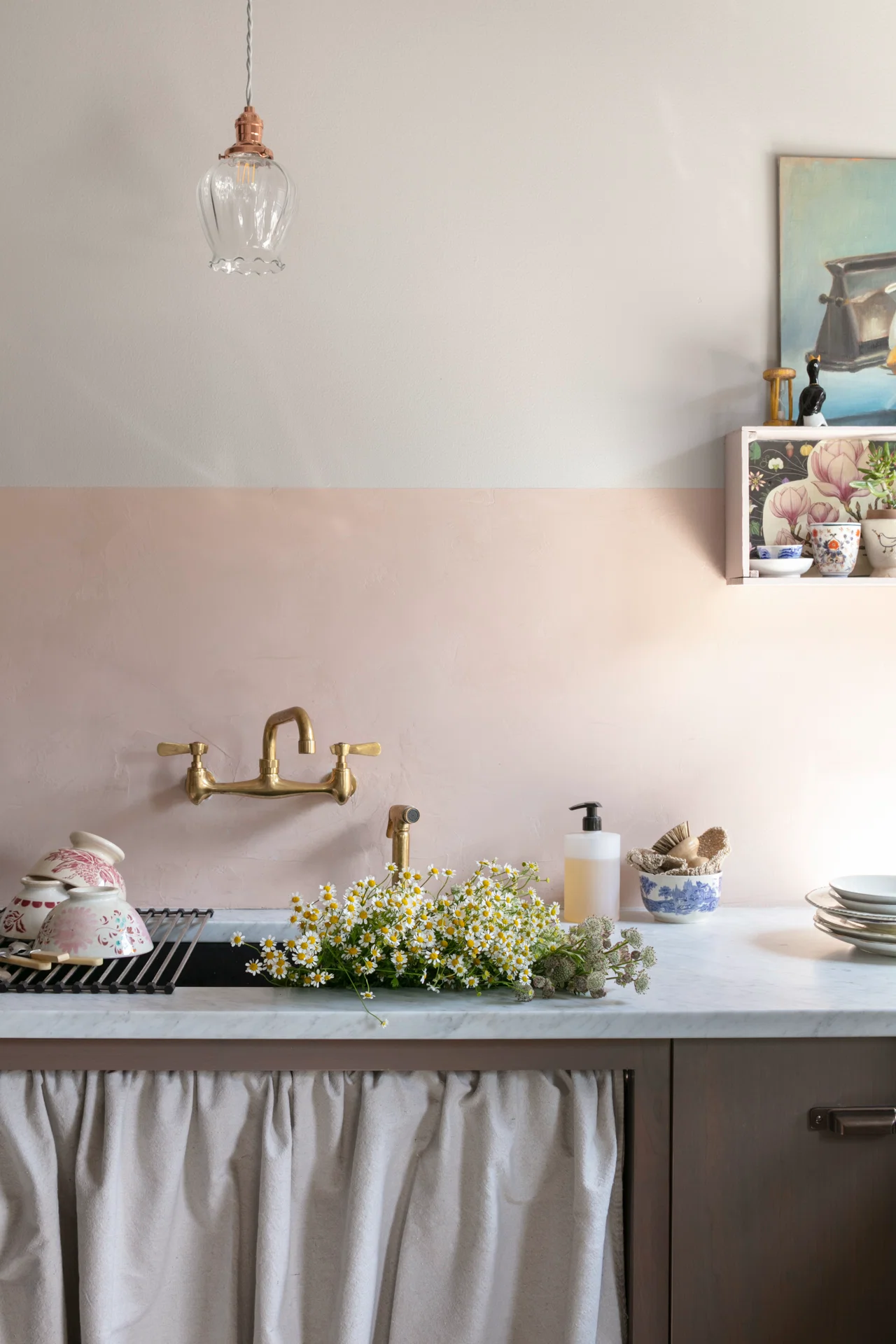 pretty kitchen scene at sink with flowers a sink curtain venetian plaster wall brass wall faucet glass shade pendant