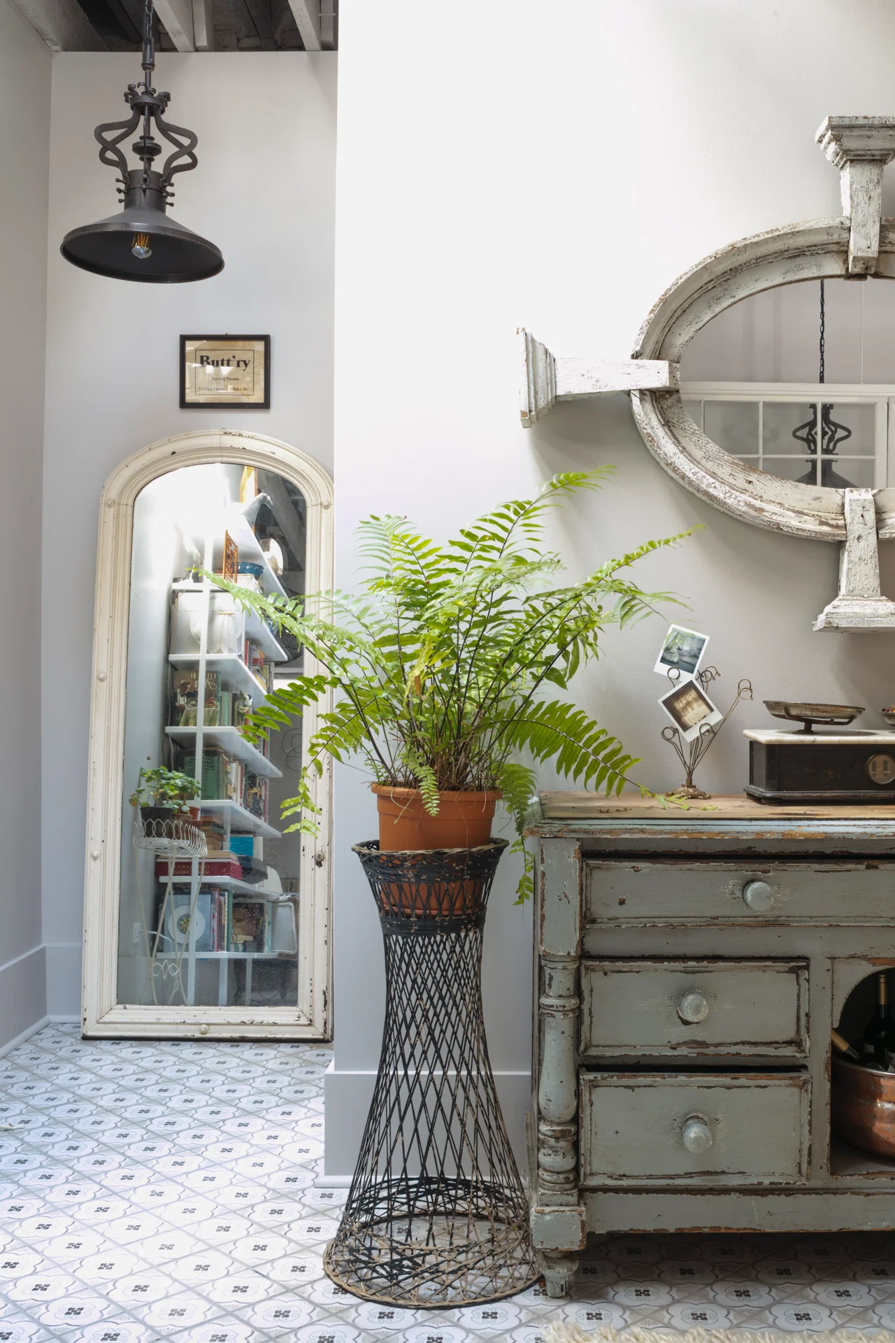 interipr scene hallway with antique pine sideboard tall mirror fern in woodard planter tiled floor