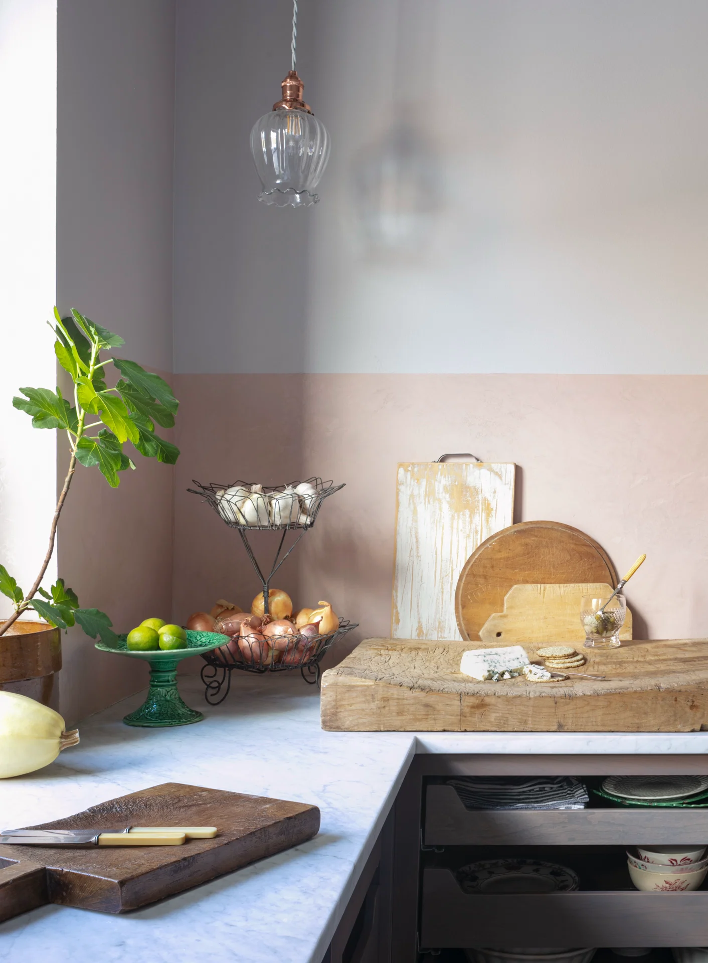 interior kitchen scene marble countertop with chunky cutting boards baskets of fruit fig venetian plaster 