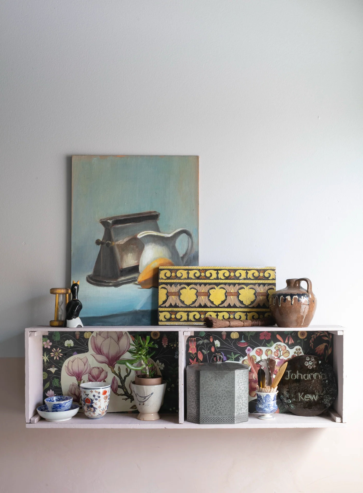 quirky open wall hung shelf with oil painting and assorted knick knacks vintage tile blue white china