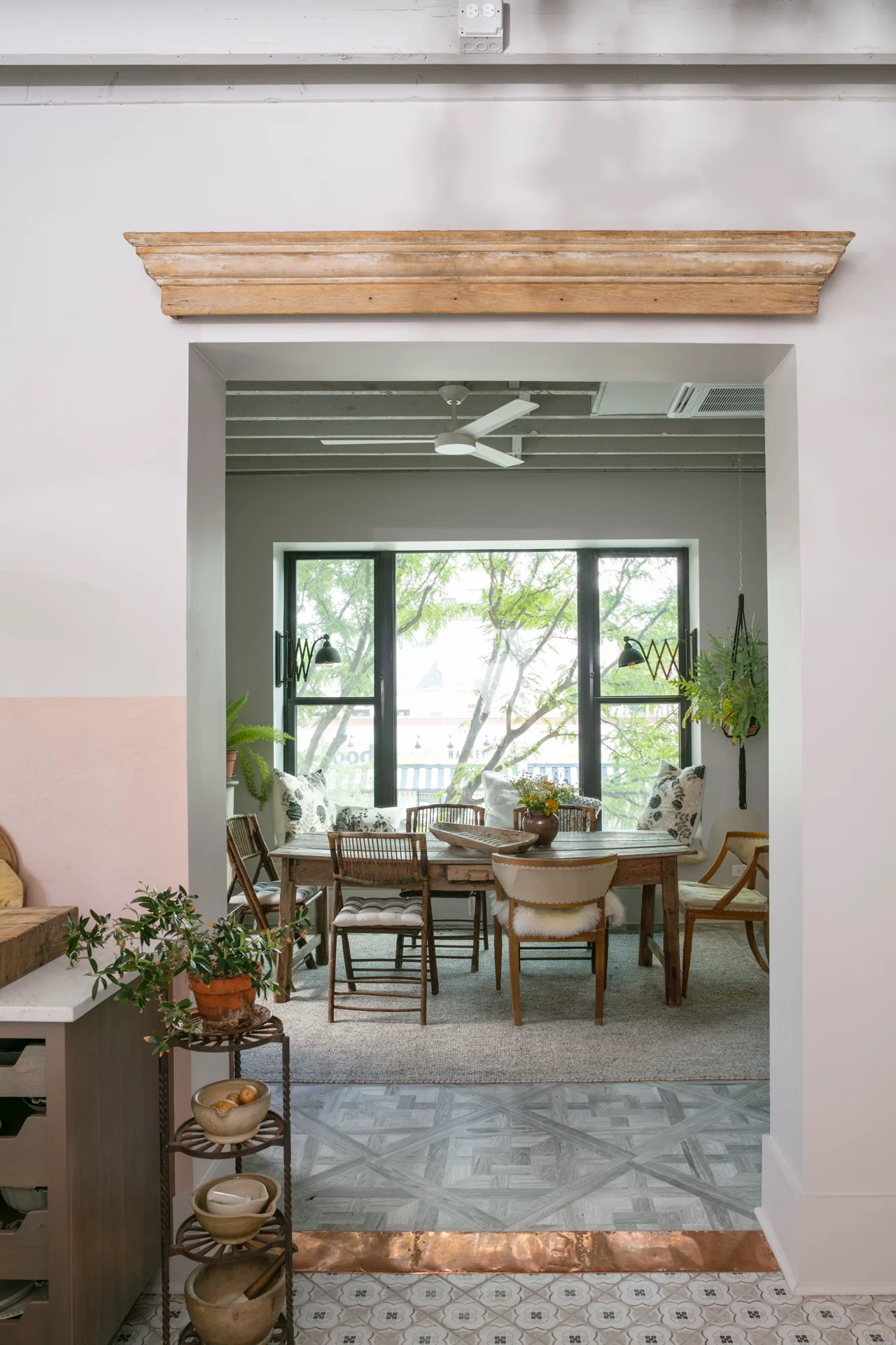 interior scene dining room through archway pediment copper floor large windows restoration hardware dining chairs tiled floor