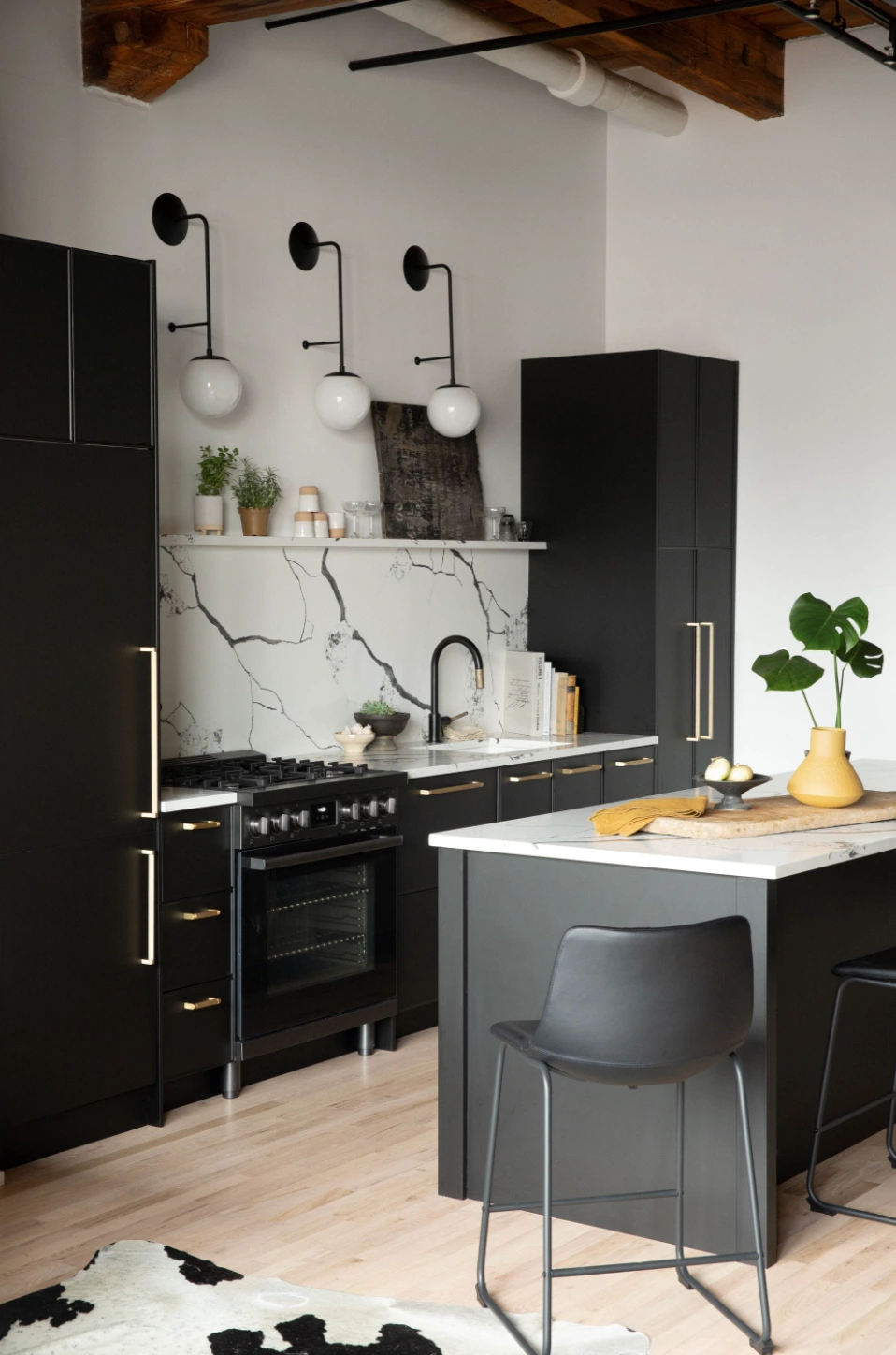 contemporary modern black and white kitchen with island and bar stool french bistro milk glass wall sconces dramatic heavy veined marble backsplash
